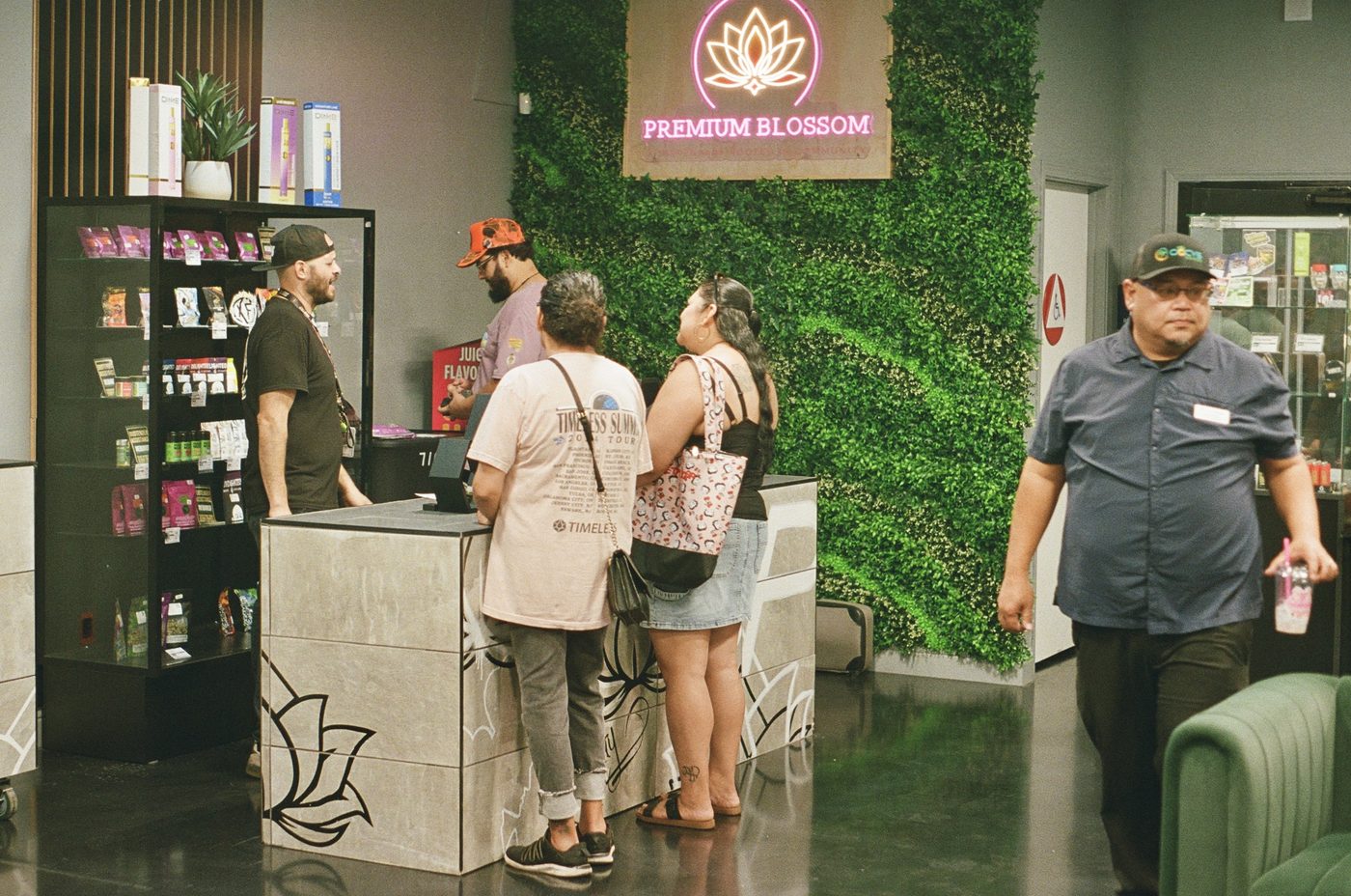 Premium Blossom customers at the counter, opening day, shot on 35mm