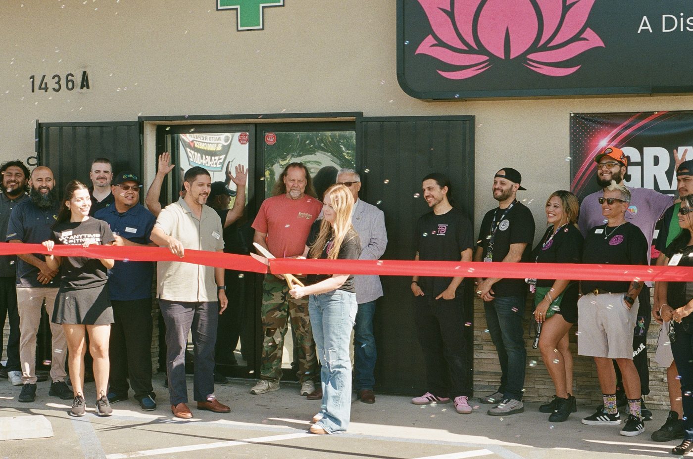 Premium Blossom grand opening &mdash; ribbon cutting with staff and crowd, shot on 35mm